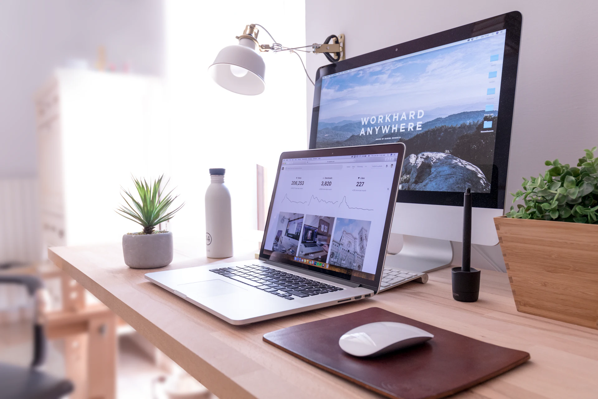 Een website op een laptop en een desktopscherm op een lichte werkplek